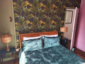 吉斯伯勒Garden Cottage的一间卧室配有一张带热带壁纸的床