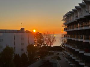 科沃布热格Seaside Park Hotel Kołobrzeg apartament 27 metrów szczęścia的享有建筑和大海的日落美景