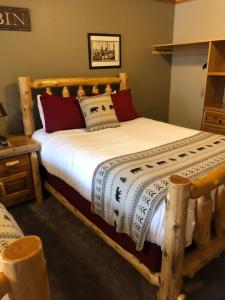 Summit Lake苏米特湖畔旅舍的一间卧室配有一张带白色床单的木床