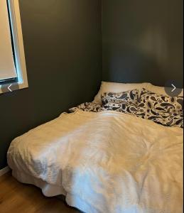 弗维克Sjønær leilighet på fevik!的卧室内的一张床铺,配有白色棉被