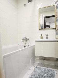 苏梅Esplanada aparments的白色的浴室设有浴缸和镜子