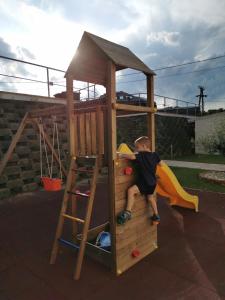欧尔菲Life Apartman Orfű的一个小男孩在木游戏房爬上
