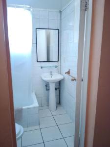 维纳德马Aquamarina Apart Hotel的白色的浴室设有水槽和镜子