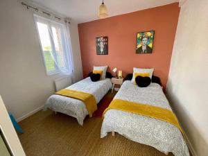 Villenyla Casa d'Olianna - Jolie Maison / Jeux / Grand jardin的橙色墙壁客房的两张床