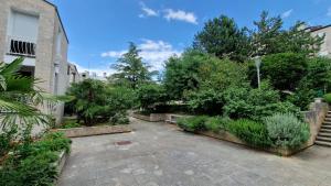 奈维斯Apartman Bela的种有大量植物和树木的庭院