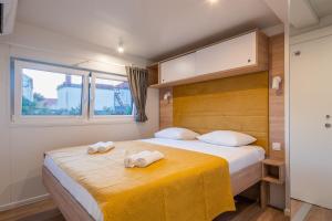 苏科尚Giardino Sukošan - new mobile houses in olive garden, EV plug-in station的一间卧室配有一张床,上面有两条毛巾