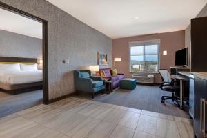 佩塔卢马Home2 Suites By Hilton Petaluma的配有一张床和一张书桌的酒店客房