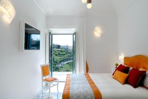 斯卡拉Residence Villa Ruocco的白色的卧室设有一张大床和一个窗户