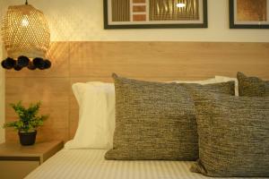 麦德林First Class Hotel by 5 Host的一间卧室配有带枕头和台灯的床