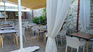 阿拉恰特Neva Hotel Alaçatı的一个带桌椅和白色遮阳伞的庭院。