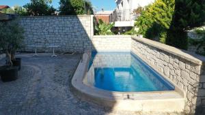 阿拉恰特Neva Hotel Alaçatı的一座带泳池壁的石头墙游泳池