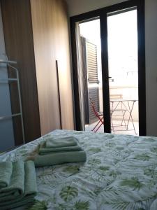 科米索Biancaura sunlight的一间卧室配有一张带绿毛巾的床
