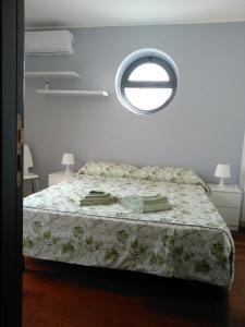 科米索Biancaura sunlight的一间卧室设有一张床和一个圆形的窗户。