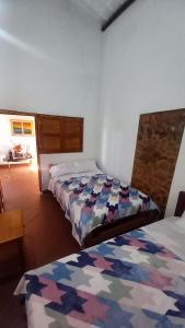 San José de SuaitaHostal posada San jose的一间客房内配有两张床的房间