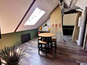 鲁昂Logement Industriel & Atypique的一间带桌子和天窗的用餐室