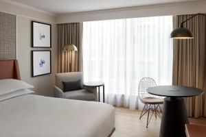 米西索加多伦多国际机场喜来登酒店的配有床、椅子和桌子的酒店客房