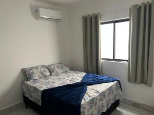 康德Carapibus casa de praia 02的一间小卧室,配有一张带窗户的床