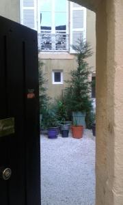 欧坦Chambre d'hôte au 3ème étage d'une maison de chanoine的通往种植盆栽的庭院的开放式门