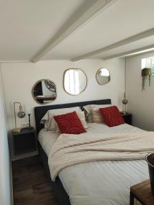 Grez-DoiceauÔ nature的一间卧室配有一张大床和两个红色枕头