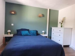 Saint-AlbanL'inattendu的一间卧室配有蓝色的床和白色梳妆台