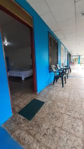 卡维塔Miss Magi cahuita rooms的一间设有蓝色墙壁、椅子和一张床的客房