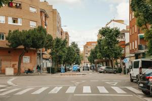 塔拉韦拉·德·拉·雷纳Casa a 3 minutos del Casco y con facil aparcamiento- El rincón de Carmela的一条空荡荡的城市街道上,有汽车停在街上