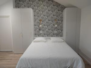 第戎Place Barbe的卧室配有白色的床和墙壁