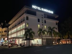 哥打京那巴鲁Hotel Bundusan的夜间标有标志的酒店大楼