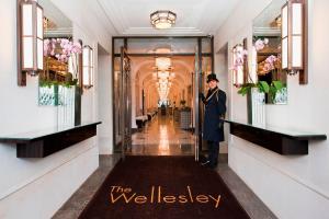 伦敦The Wellesley, a Luxury Collection Hotel, Knightsbridge, London的站在建筑物走廊上的女人