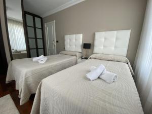 乌迪亚莱斯堡Villa OLYMPIA的一间设有两张床铺和毛巾的房间