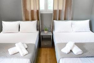 帕拉利亚潘塔利莫诺斯NikoleTakis Apartments的配有2张床的带白色床单和枕头的客房