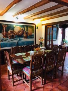 莱瓦镇Hotel Villa Cristina的一间带桌椅和绘画的用餐室