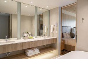 因弗米尔Headwaters Lodge at Eagle Ranch Resort的一间带两个盥洗盆和大镜子的浴室