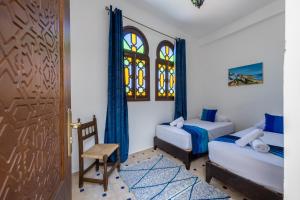 丹吉尔Riad SULTANA的卧室配有床、椅子和门
