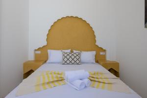 丹吉尔Riad SULTANA的一张带木制床头板和毛巾的床