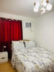 达沃市Italian Inspired Condo in Davao by AAG的一间卧室配有床和红色窗帘