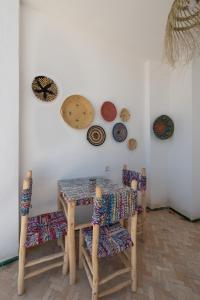 丹吉尔Riad SULTANA的墙上一张桌子和椅子,上面有盘子