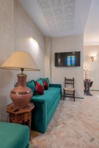 丹吉尔Riad SULTANA的客厅配有绿色沙发和灯具