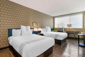 萨凡纳GLo Best Western Pooler - Savannah Airport Hotel的酒店客房配有两张床和一张书桌
