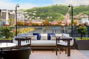 毕尔巴鄂Radisson Collection Bilbao的享有带桌椅的屋顶露台的景致。