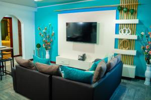 Escappé Suites的客厅拥有蓝色的墙壁,配有带枕头的沙发。