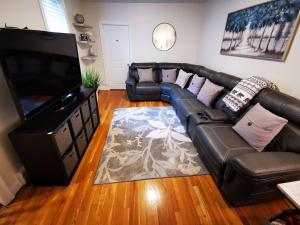 波士顿Location+Comfort+Convenience的客厅配有真皮沙发和平面电视