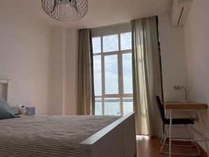 阿亚蒙特Apartamento Atardeceres的一间卧室配有一张床、一张书桌和一个窗户。