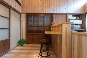 冲岛guesthouse碧的一间带木墙的厨房和一间带凳子的酒吧