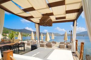 马尔马里斯Naxos Beach Hotel的一间带桌椅并享有水景的餐厅