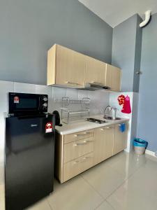 塞贝维Modern Dpulze Soho fit 4pax,Netflix provided的厨房配有黑色冰箱和微波炉。