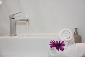 圣尼古拉奥斯Alkyoni Apartments的白色的浴室设有毛巾和水槽