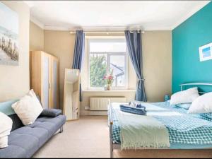 卡迪夫The Mews的蓝色的卧室配有床和沙发