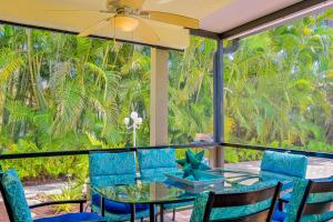 那不勒斯The Rainbow Villa的一个带玻璃桌和椅子的庭院,并种植了棕榈树