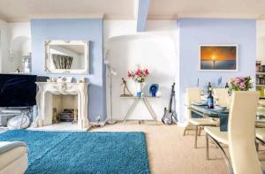 卡迪夫The Mews的客厅设有蓝色的墙壁、桌子和壁炉